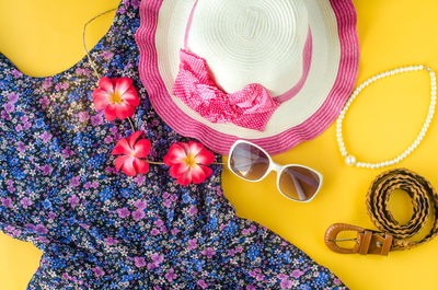 High angle view of personal accessories on yellow background