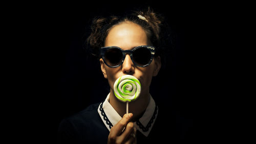 Close-up portrait of young woman holding lollipop