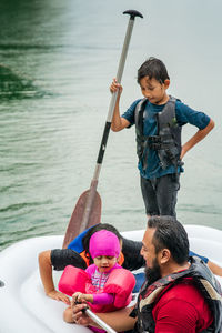 Family on pool raft over lake