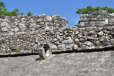 Low angle view of stone wall against clear sky