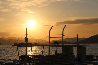 Silhouette ship on sea against sky during sunset