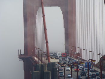 Cars moving on bridge during foggy weather