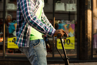 Man holding umbrella standing against city