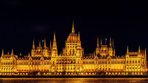 Illuminated city against sky at night