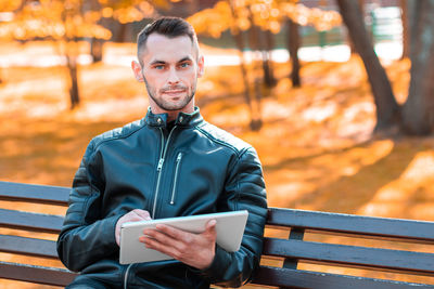 Portrait of young man sitting on bench