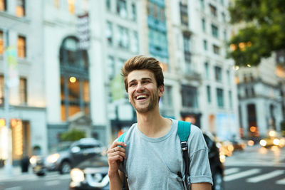 Portrait of young man standing in city