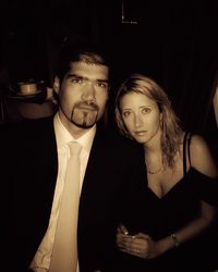 Portrait of young couple standing against black background