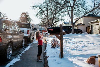 Young girl putting letter in mail box