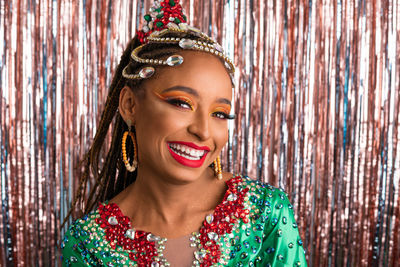 Portrait of young woman standing against christmas tree