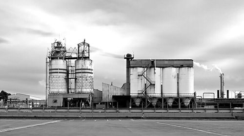 Industrial building against cloudy sky