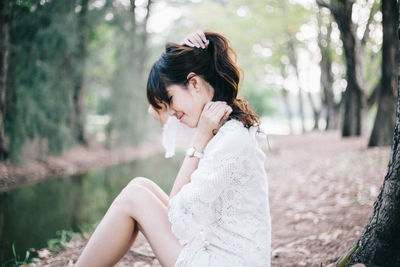 Side view of young woman in forest