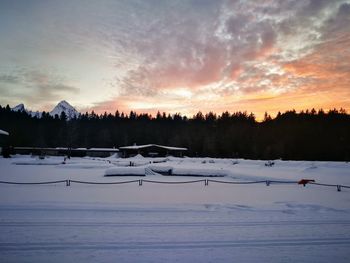 Scenic view of snow field against sky at sunset