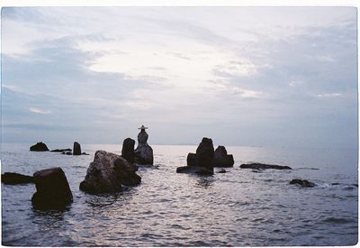 Rocks on sea shore against sky