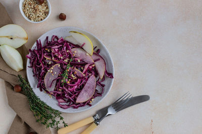 Red cabbage, pear and hazelnut salad with lemon and olive oil sauce.  vegetarian food.