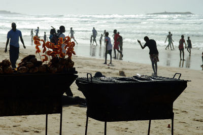 People by barbecue at beach