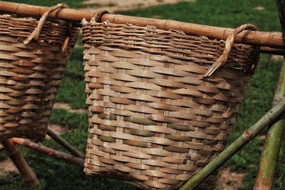 Close-up of wicker basket hanging on wood in field