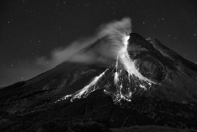 Scenic view of snowcapped mountain against sky at night