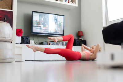 Side view of woman lying on floor at home