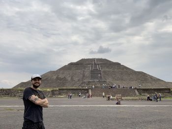 Portrait of man standing against historic building