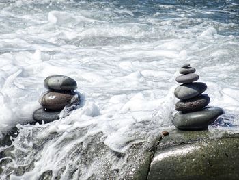 Stack of stones in sea during winter