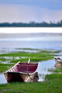 Boat moored on beach against sky