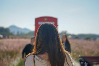 Rear view of woman standing against sky