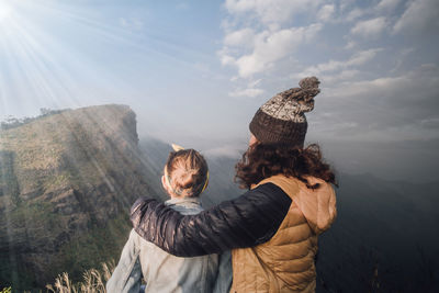 Rear view of friends standing against sky