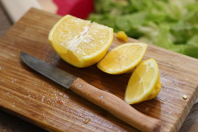 High angle view of lemon and knife on cutting board