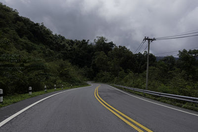 Road amidst trees against sky