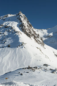 Scenic view of snowcapped mountains against clear sky