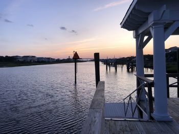 Pier over sea against sky during sunset