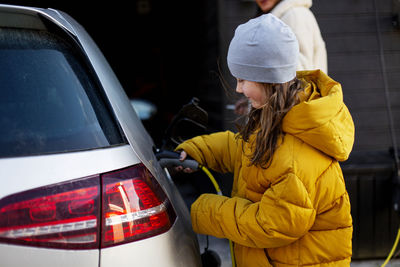 Girl charging electric car