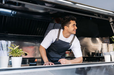 Portrait of young man preparing food at restaurant