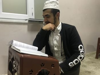 Young man sitting on book