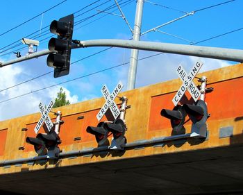 Low angle view of railroad crossing against blue sky