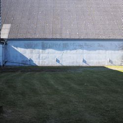 Exterior of building in front of field during sunny day
