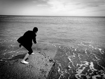 Rear view of man on beach against sky