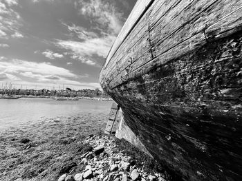 Abandoned boat on beach against sky