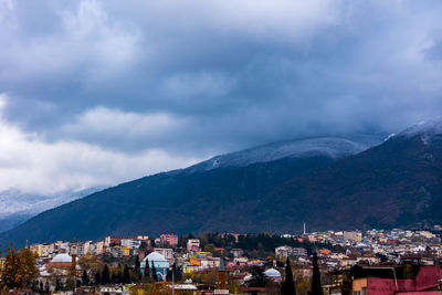 Townscape by mountains against sky