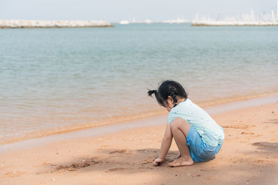 Rear view of woman standing at beach