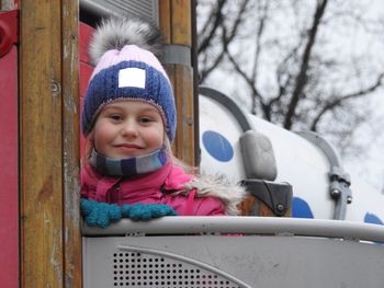 Portrait of girl smiling on play equipment during winter