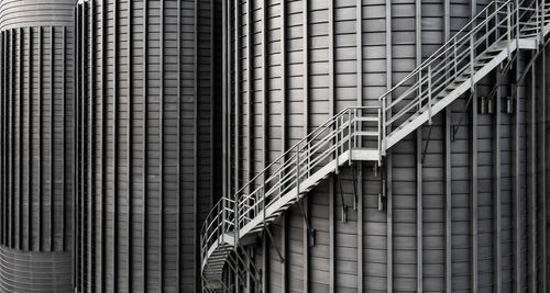 Close up of large, industrial storage tanks or silos with external step ladders with copy space