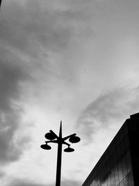 Low angle view of street light against cloudy sky