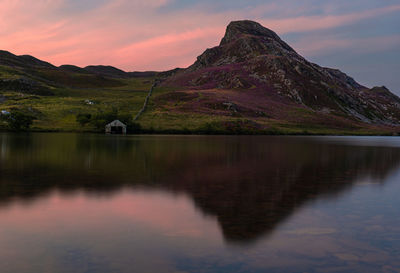 Scenic view of lake and mountains against sky during sunset