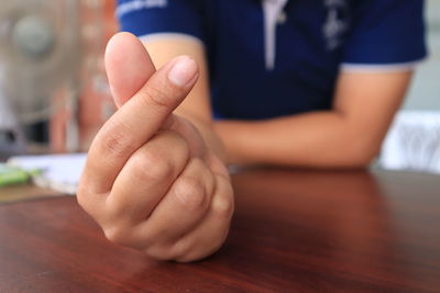 Close-up of man sitting on table