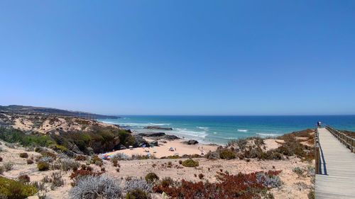 Scenic view of beach against clear blue sky