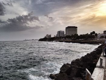 Silhouette of buildings and seascape during sunset