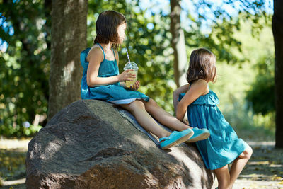 Two little girls drinking lemonade in park