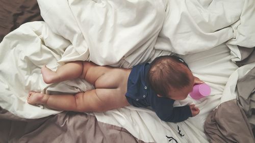 High angle view of baby boy lying on bed at home