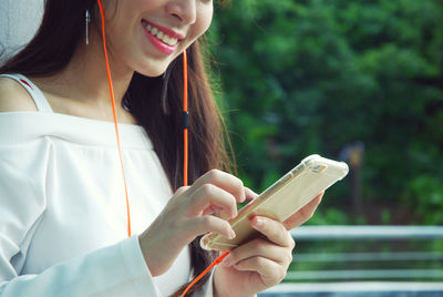 Midsection of woman using mobile phone